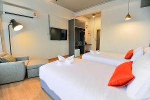a hotel room with a couch, coffee table and a television at 7 Days Premium Hotel Pattaya - SHA Extra Plus in Pattaya South