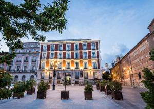 un grand bâtiment avec bancs devant lui dans l'établissement Intelier Palacio San Martin, à Madrid