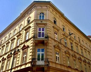 ブダペストにあるHomelike luxury flat on Gyulai Pálの窓とバルコニー付きの大きな黄色の建物