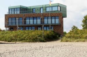 a building on the beach next to the sand at Strandappartements Haus Strandkieker in Schönhagen