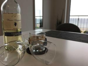 a bottle of wine and glasses on a table at Strandappartements Haus Strandkieker in Schönhagen