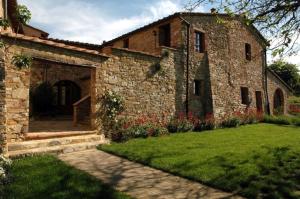 an old brick building with a door and a yard at Fattoria Casa Sola in Barberino di Val dʼElsa