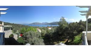 een uitzicht vanuit een huis met bomen en een meer bij Gera's Olive Grove - Elaionas Lesvou in Perama