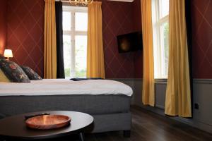 een slaapkamer met een bed en een tafel met een kom erop bij Villa Göta in Forsvik