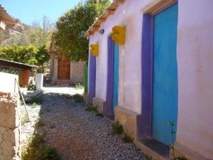 a row of houses with blue doors on a street at Casa Colores in Tilcara