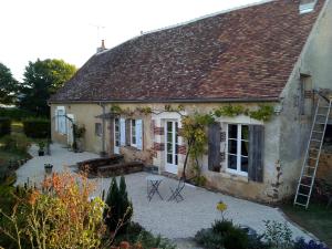 an old stone house with a patio in front of it at La Treille in Treigny