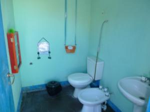 Baño azul con 2 aseos y lavamanos en Casa Colores en Tilcara