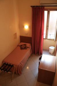 a small bedroom with a bed and a window at Hotel Cherubini in Rome