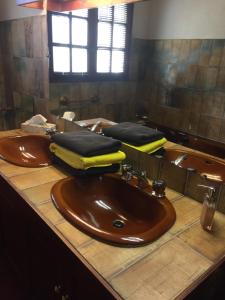 La salle de bains est pourvue de 2 lavabos bruns et d'un miroir. dans l'établissement Mariandre chambre chez l'habitant, à Biscarrosse