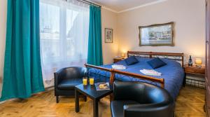 sypialnia z niebieskim łóżkiem i 2 krzesłami w obiekcie Apartments Legendary Kraków w Krakowie