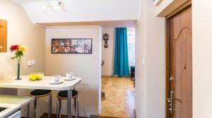 una cocina con una pequeña mesa blanca y taburetes en Apartments Legendary Kraków, en Cracovia
