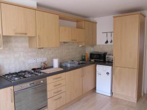 a kitchen with wooden cabinets and a white refrigerator at River Walk Inverness in Inverness