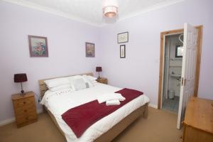 Poppyfield House, Kenmare في كينماري: غرفة نوم بسرير كبير مع بطانية حمراء