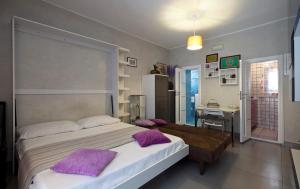 una camera da letto con letto con cuscini viola e scrivania di Casa Nocelle a Napoli