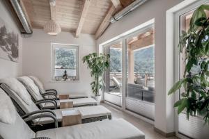 a living room with a couch and chairs and windows at Soelden Lounge in Sölden