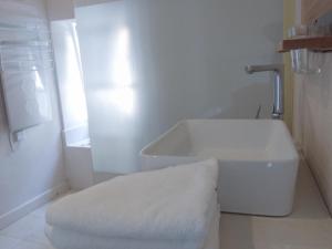 a white bathroom with a tub and a sink at Living-in-History: Heidi Braun Cottage in Dudeldorf