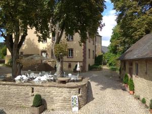 a patio with tables and chairs in front of a building at Living-in-History: Heidi Braun Cottage in Dudeldorf