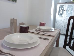 a table with two white plates on top of it at Living-in-History: Heidi Braun Cottage in Dudeldorf +18 photos