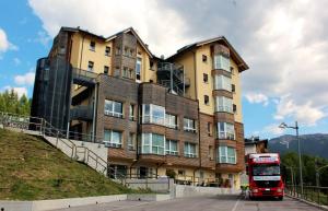 un autobús rojo está estacionado frente a un edificio en Antelao Dolomiti Mountain Resort en Borca di Cadore