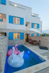 una casa con piscina con due fenicotteri gonfiabili di Villa Miri a Privlaka (Brevilacqua)