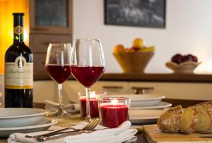 una mesa con dos copas de vino y una botella de vino en Casetta Carmine, en Asolo