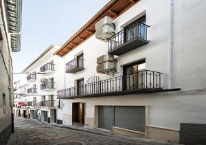 a white building with balconies on a street at Nuevo Monteftur in Montefrío