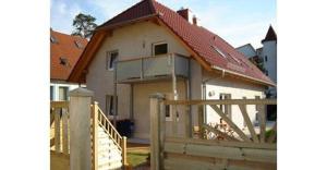 ein weißes Haus mit einem Tor und einem Zaun in der Unterkunft Ferienwohnungen Ostsee & Mehr in Heringsdorf