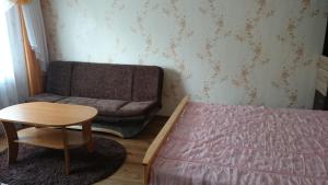 ein Schlafzimmer mit einem Bett, einem Sofa und einem Tisch in der Unterkunft Апартамент в центре города, Stacijas 111 in Daugavpils