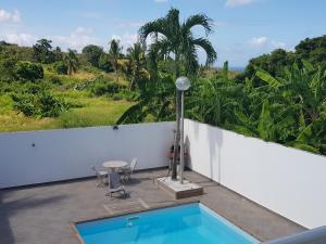 a swimming pool on the balcony of a house at Bungalow Akwarel in Vieux-Habitants