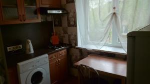 eine Küche mit einer Waschmaschine und einem Fenster in der Unterkunft Апартамент в центре города, Stacijas 111 in Daugavpils