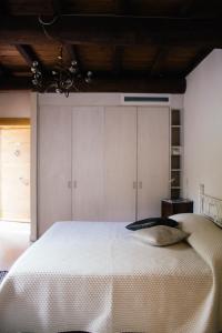 a bedroom with a large white bed with a wooden ceiling at Agriturismo La Burlanda in Fosdinovo