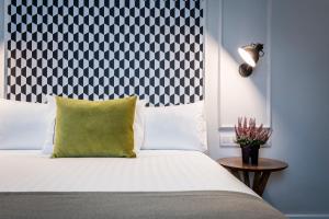 a bedroom with a bed with a black and white headboard at Intelier Victoria in San Sebastián