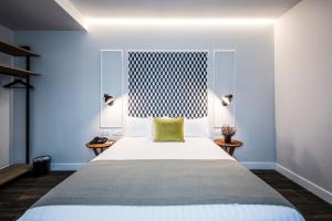 1 dormitorio con 1 cama grande con almohada amarilla en Intelier Victoria, en San Sebastián