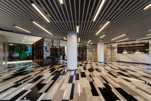 a lobby of a building with columns and a ceiling with lights at Boudl Al Corniche in Dammam