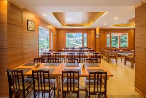a restaurant with wooden walls and tables and chairs at Hotel Batseri SANGLA in Sāngla