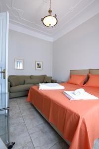 1 dormitorio con cama con sábanas de color naranja y sofá en Acheiropoietos Apartment, en Tesalónica