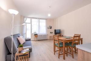 een woonkamer met een tafel en stoelen en een bank bij Atacama - spacious apartment in Lozenets area in Sofia