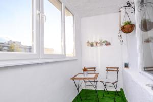 um quarto com duas cadeiras e uma mesa com um tapete verde em Atacama - spacious apartment in Lozenets area em Sófia