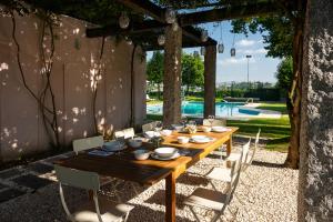 a wooden table and chairs in a yard with a pool at Casa da Cachada in Felgueiras