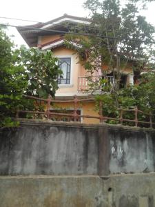 a house behind a concrete wall with a fence at Colombo 20 minutes by train in Wattala