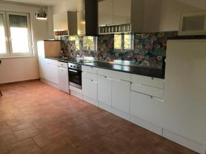 豪伊杜索博斯洛的住宿－Diamond house，厨房配有白色橱柜和瓷砖地板。