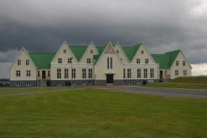a large building with green roofs and a grass field at Luxury Vacation House for Summer and Winter in Úlfljótsvatn