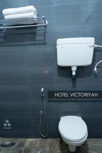 坦贾武尔Hotel Victoriyah的一间带卫生间和墙上淋浴的浴室