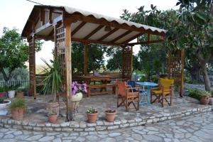 a wooden gazebo with chairs and a table at Dimitras House in Paralio Astros