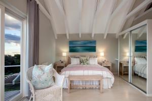 a bedroom with a bed and a large window at Protea & Pincushion Cottages in Hermanus