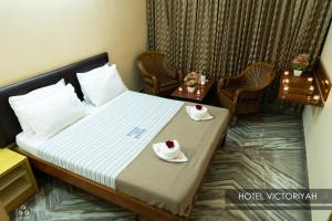 een hotelkamer met een bed met twee borden erop bij Hotel Victoriyah in Thanjāvūr