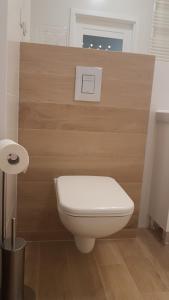 a bathroom with a white toilet in a room at Hennela Apartment in Warsaw
