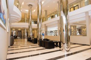 a lobby of a building with columns and couches at Crossroads Hotel Blantyre in Blantyre