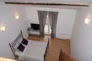 a living room with a bed and a television at Crezilles Hôtes in Crézilles