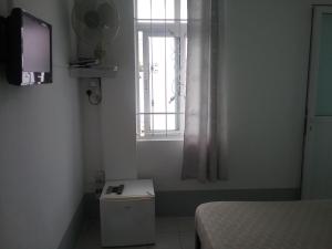 a small room with a bed and a window at La Plaine Verte Guesthouse in Port Louis